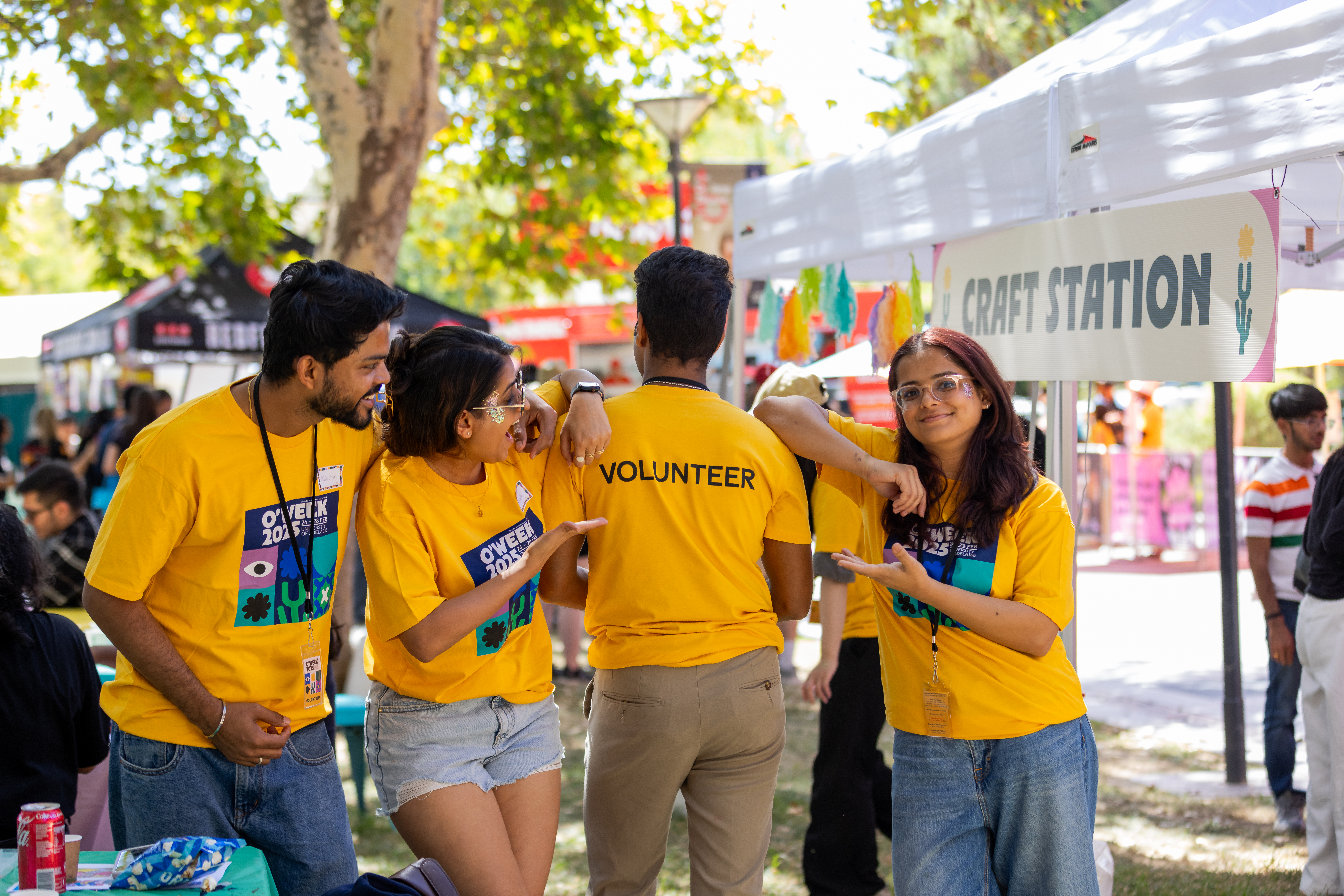 A student wearing a white shirt and lanyard hands out flyers to other passing students