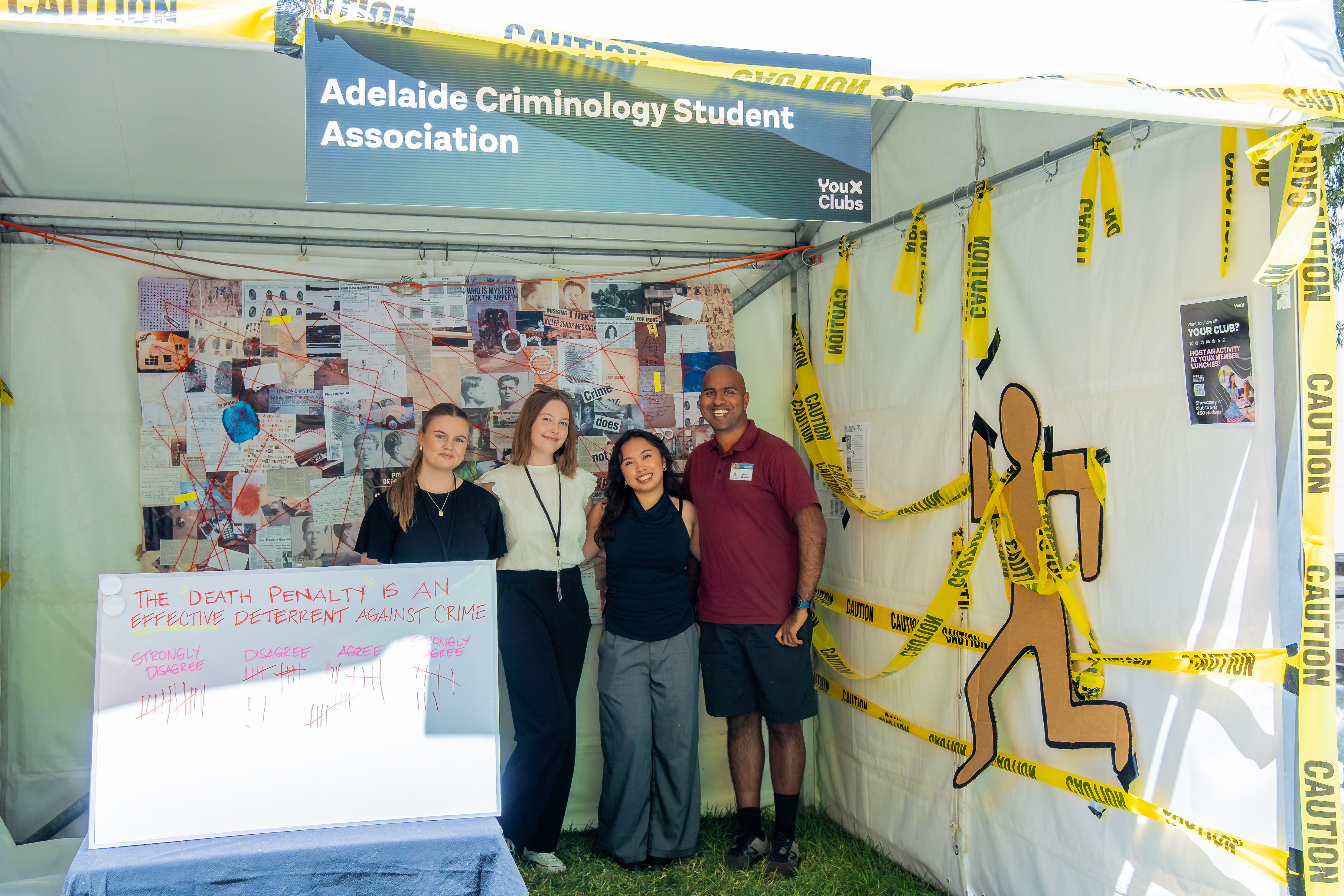 ACSA's stall decorated with caution tapes, a police board and a whiteboard asking if the death penalty is an effective deterrent against crime. This question is answered via a tally response.